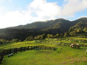 Volcan, Panama, park with green grass, a fence, and mountains – Best Places In The World To Retire – International Living